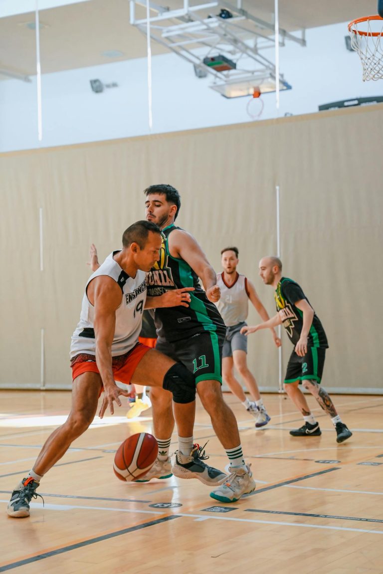 Two men playing basketball in a gymnasium
